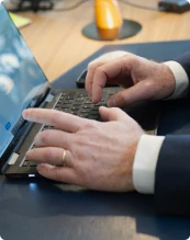 un expert-comptable en train de pointer du doigt des post-it accrochés au mur