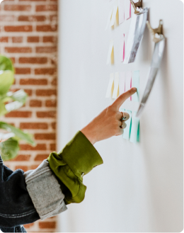 un expert-comptable en train de pointer du doigt des post-it accrochés au mur
