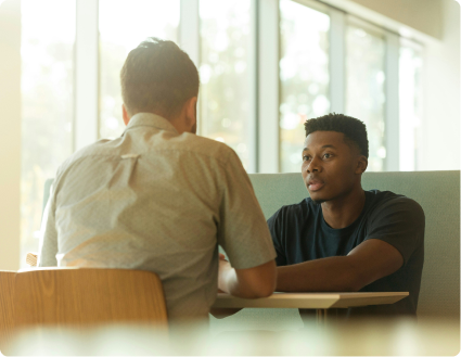 deux hommes en train de discuter autour d'une table